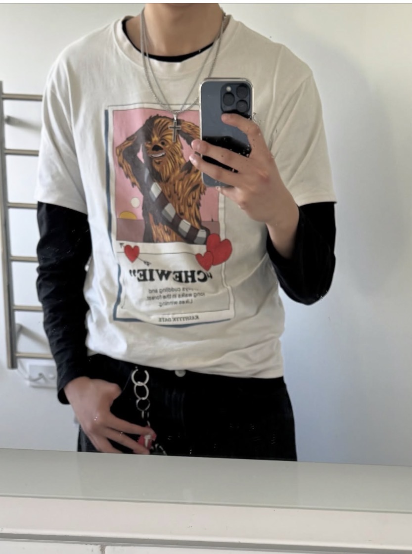 Mirror photo showing a layered graphic T-shirt over a black long sleeve